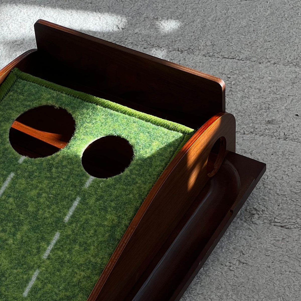 Tapis de putting Greenwood avec bois de chene, rail de retour aimanté avec détails des deux trous de différent diametre pour la précision